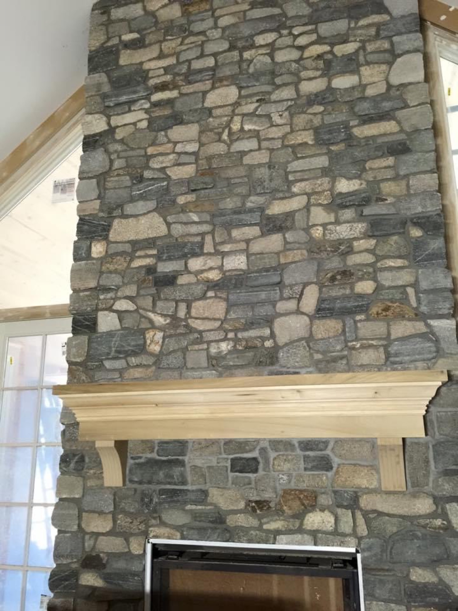 Stone fireplace with solid wood mantel
