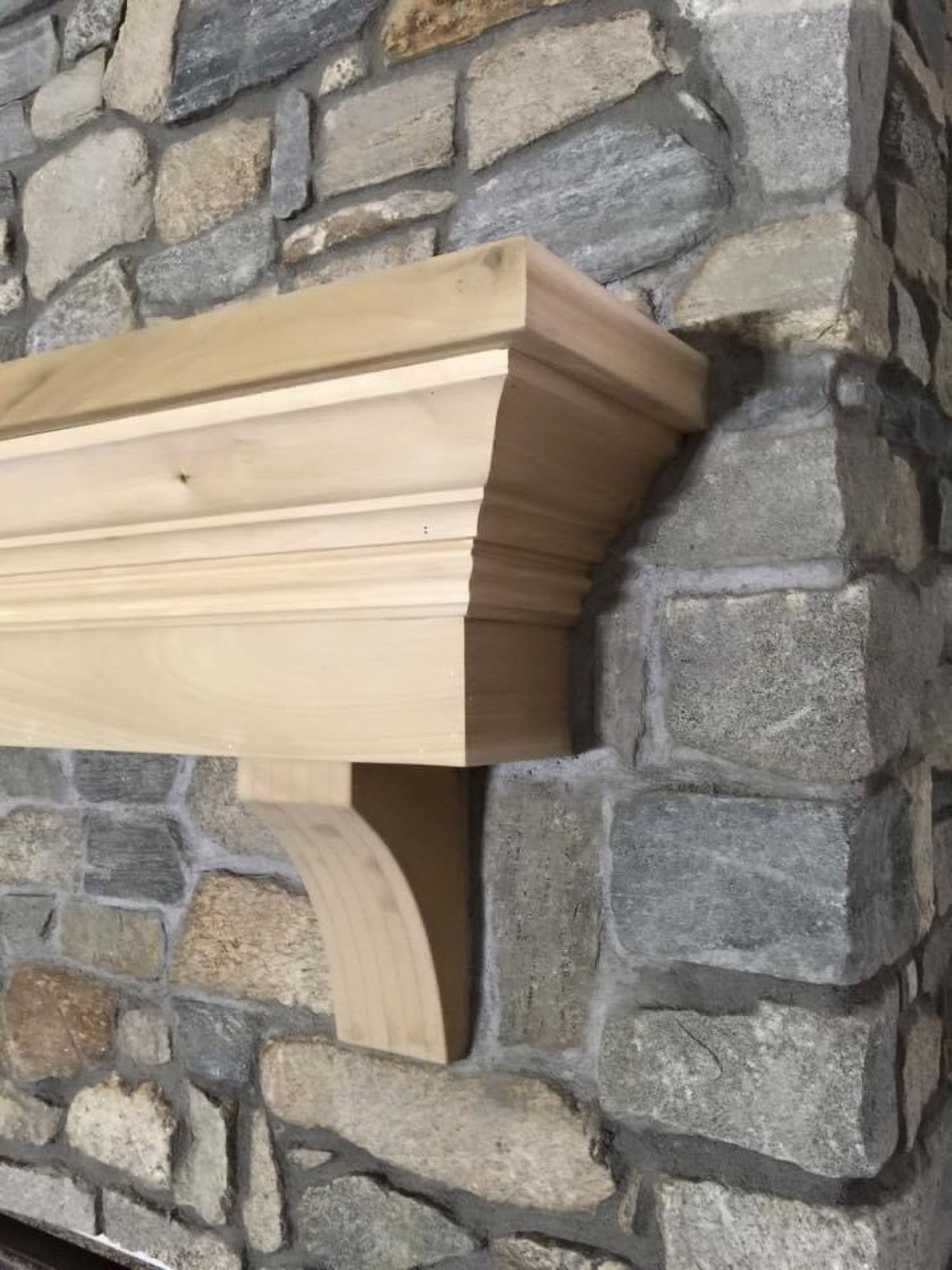 Stone fireplace detail with wood mantel