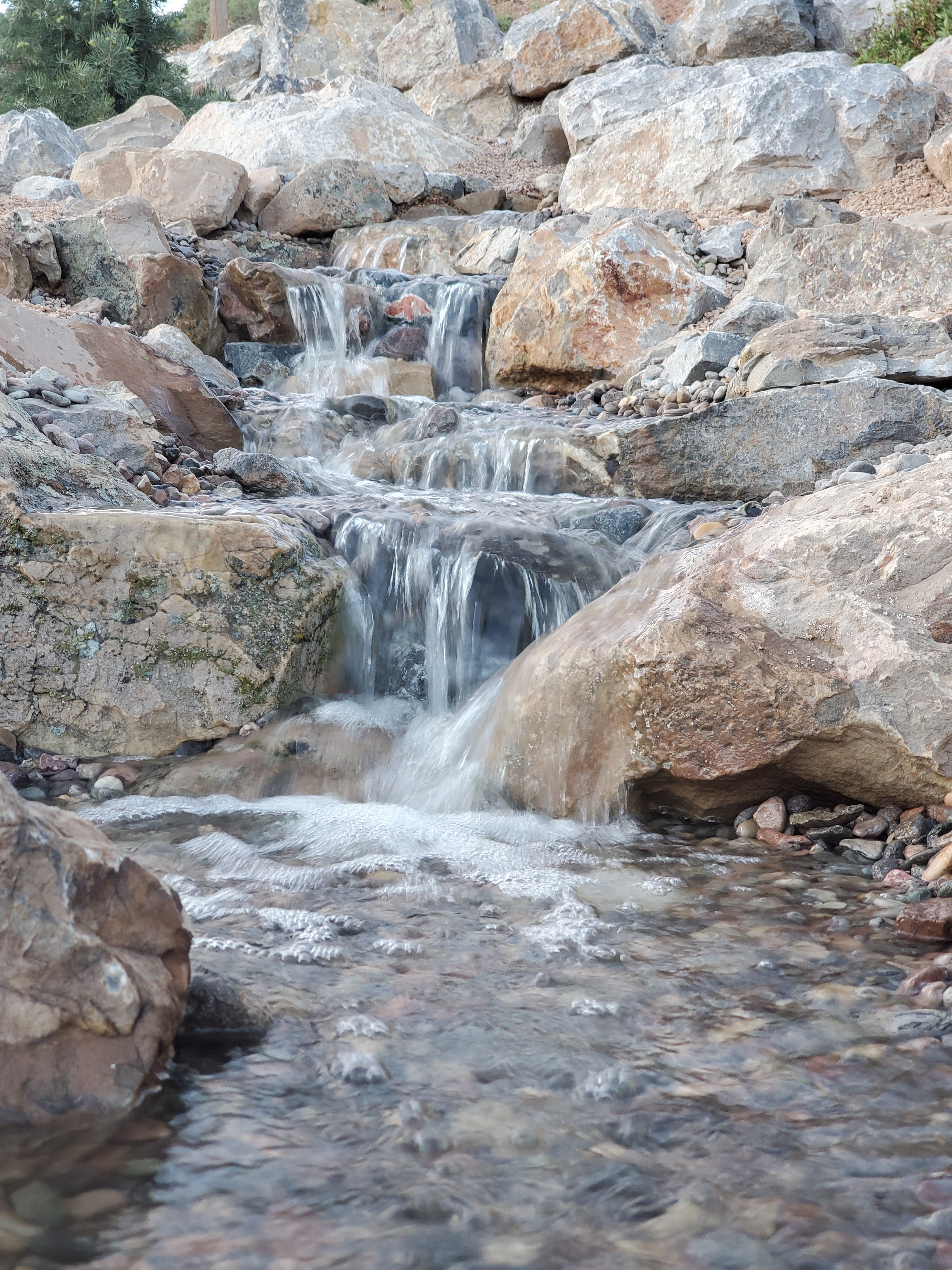Custom natural stone water feature with cascading waterfall